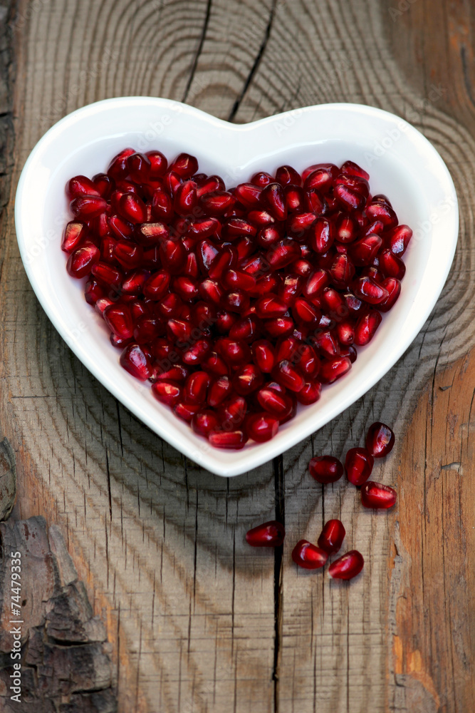 Pomegranate seeds on a plate in the form of heart Pomegranate seeds on a plate in the form of heart