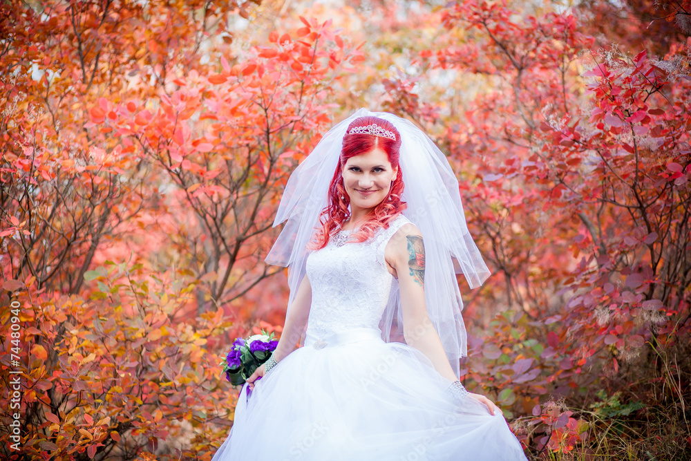 Red-haired bride on a background of red trees