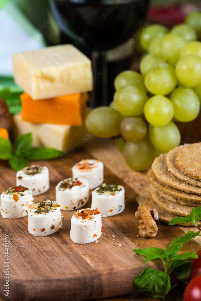 Selection of party cheese snacks with herbs on board Selection of party cheese snacks with herbs on board
