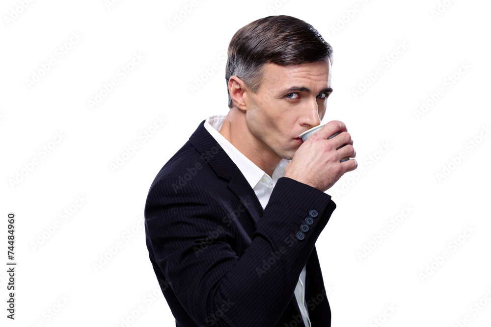 Confident businessman drinking coffee over white background Confident businessman drinking coffee over white background