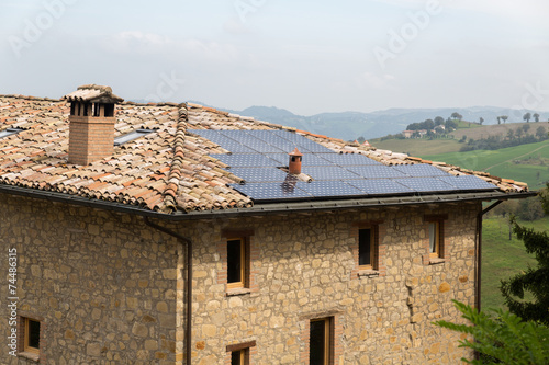 Old farm house with solar panels on the roof  Italy.