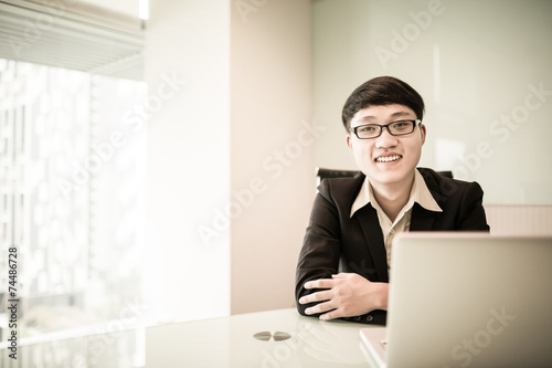 Young handsome man using laptop in his office