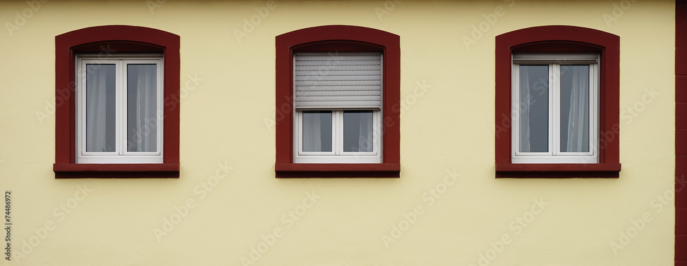 Drei moderne Kunststofffenster in Altbaufassade mit Rollläden Drei moderne Kunststofffenster in Altbaufassade mit Rollläden