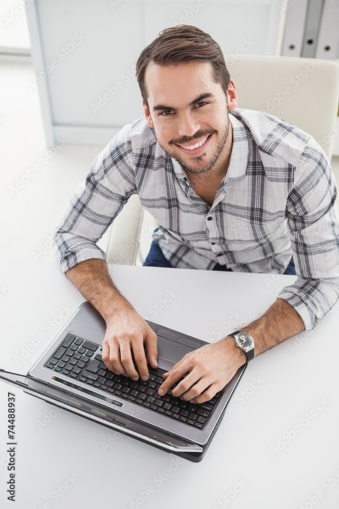 Casual businessman using his laptop at desk