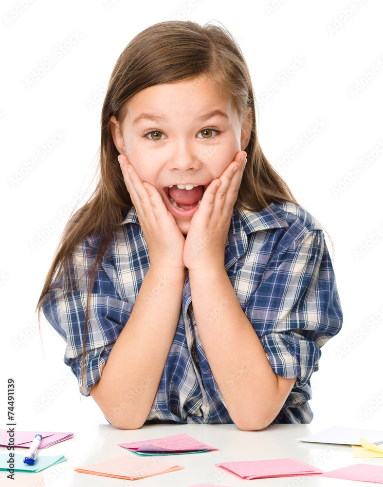 Girl is writing on color stickers using pen Girl is writing on color stickers using pen