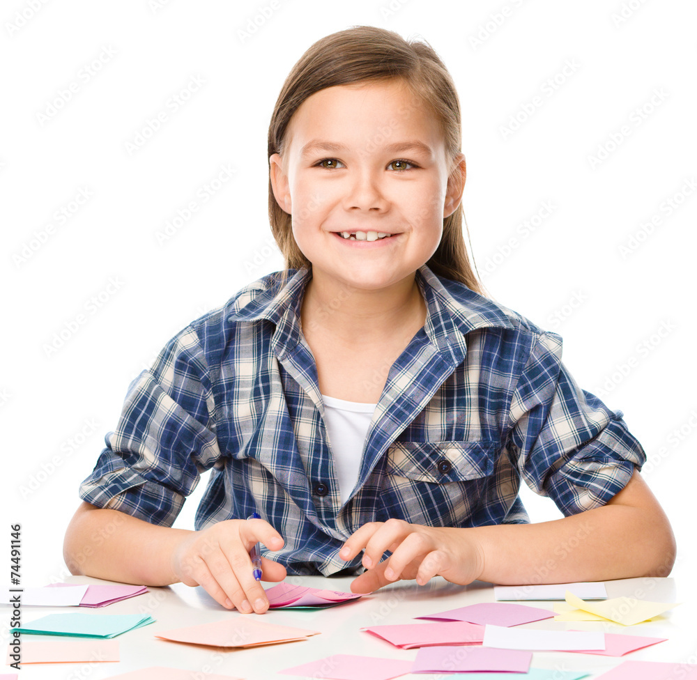 Girl is writing on color stickers using pen