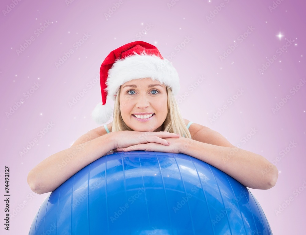 Festive fit blonde leaning on exercise ball