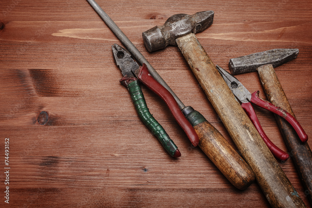 Dirty set of hand tools on a wooden panel