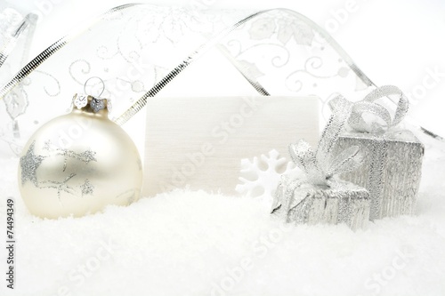 Silver christmas decoration on snow with wishes card