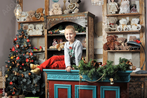 Christmas boy around the Christmas tree with gifts and toys Tedd photo