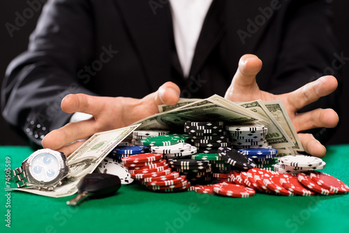 Fotografie poker player with chips and money at casino table