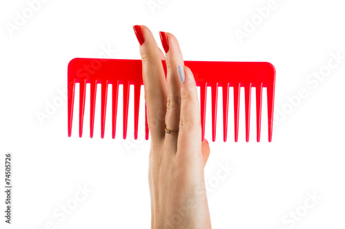 The hand of a young girl takes the red plastic brush
