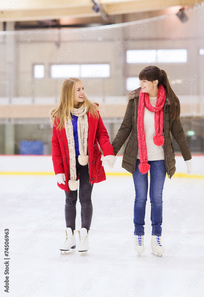 happy girls friends on skating rink