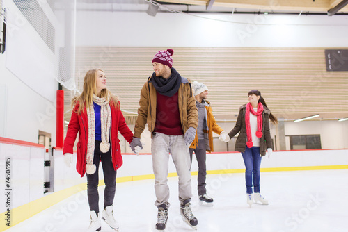 happy friends on skating rink