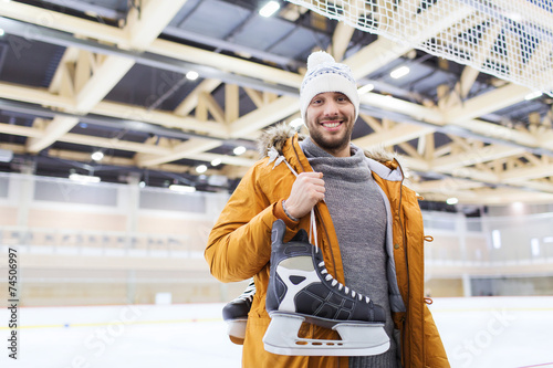 фотографія happy young man with ice-skates on skating rink