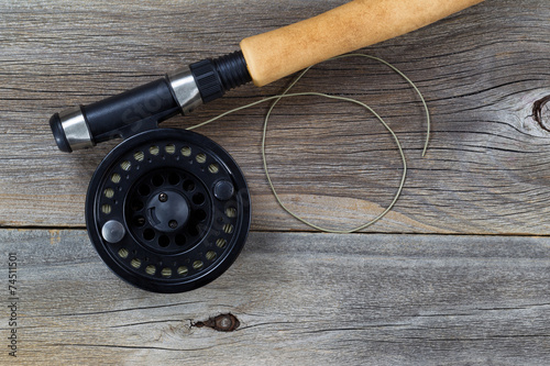 Fly Fishing Reel and Line on rustic wood