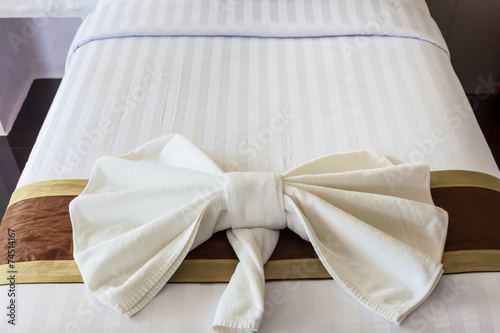 White Towel folded in bow shape on bed