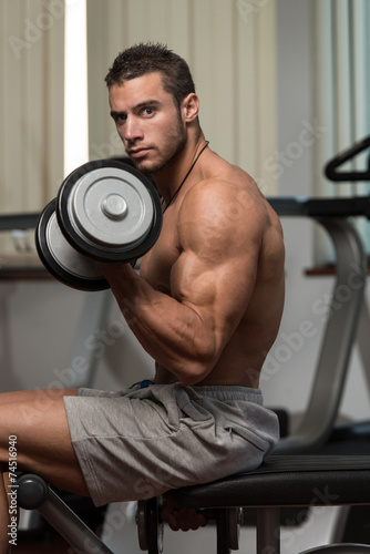 Healthy Young Man Doing Exercise For Biceps