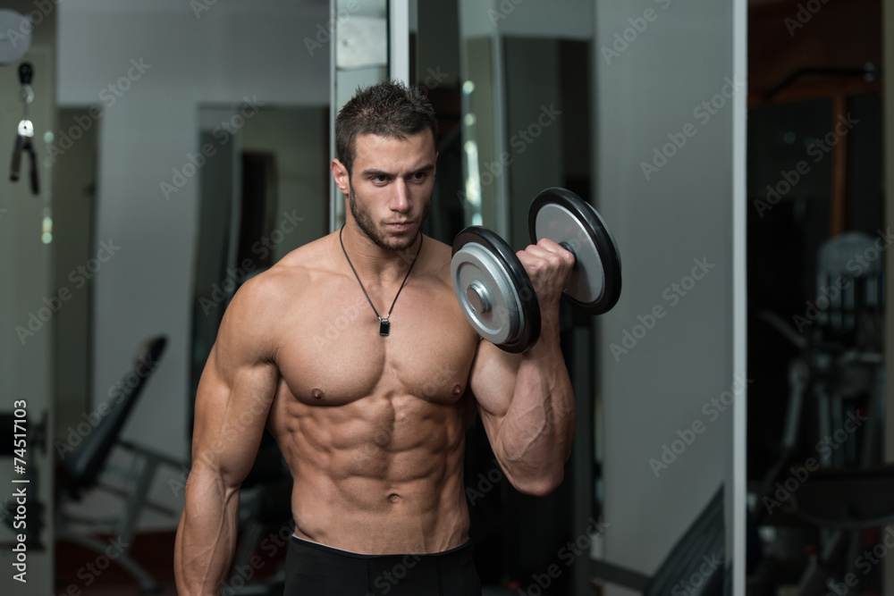 Young Male Doing Biceps Exercises In The Gym