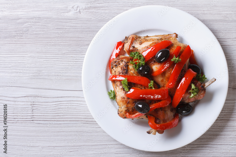 Roasted rabbit leg with peppers and olives top view horizontal Roasted rabbit leg with peppers and olives top view horizontal