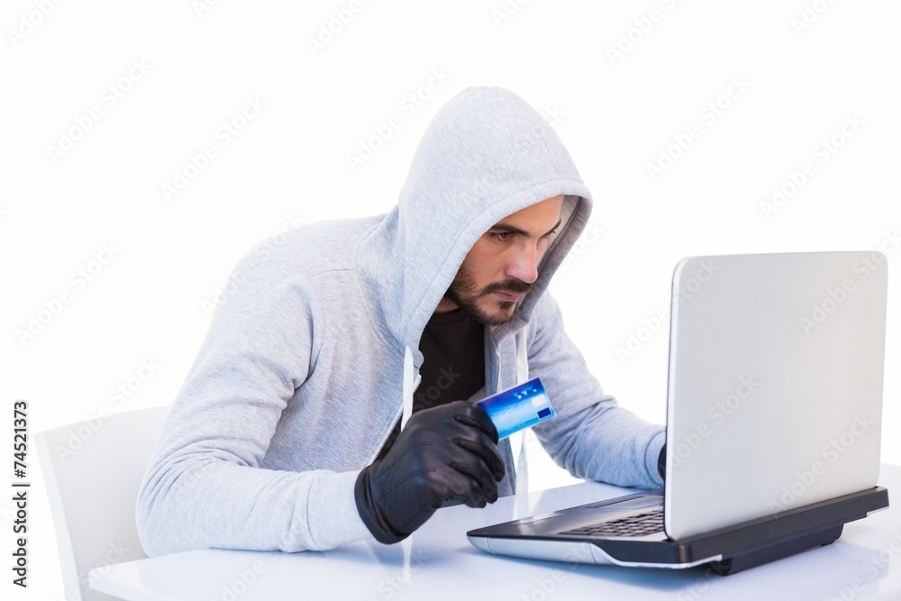 Burglar doing online shopping with laptop and credit card Burglar doing online shopping with laptop and credit card