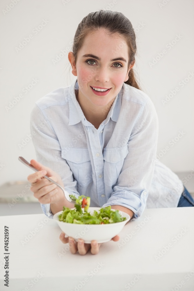 Pretty brunette eating bowl of salad Pretty brunette eating bowl of salad