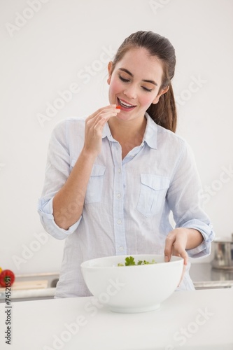 Pretty brunette eating bowl of salad