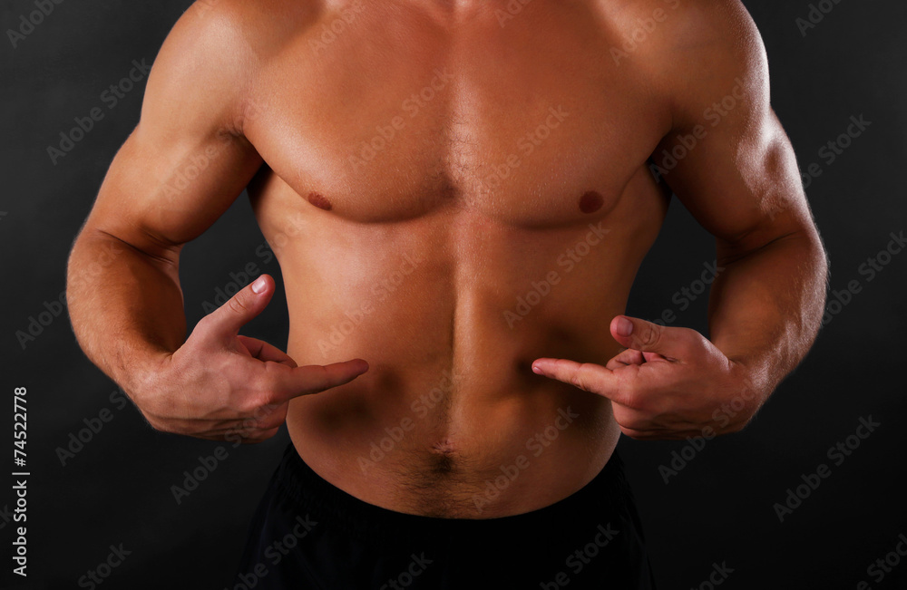 Fototapeta premium Muscle young man on dark background