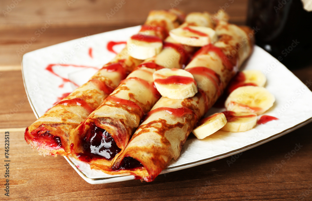 Plate of delicious pancakes with berry jam on wooden background Plate of delicious pancakes with berry jam on wooden background