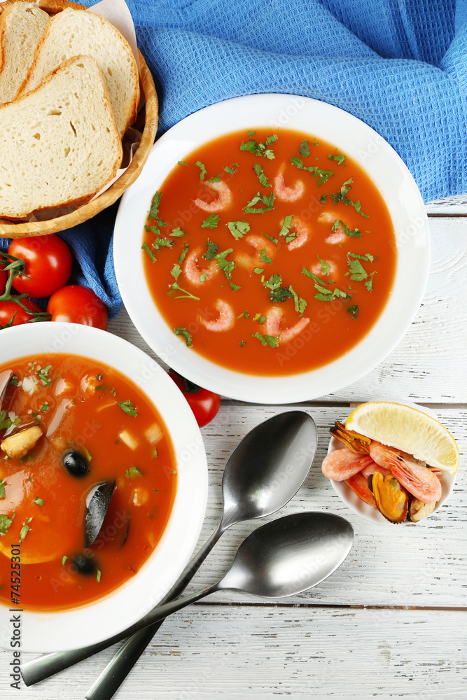 Tasty soups with sea food in bowls on wooden background Tasty soups with sea food in bowls on wooden background