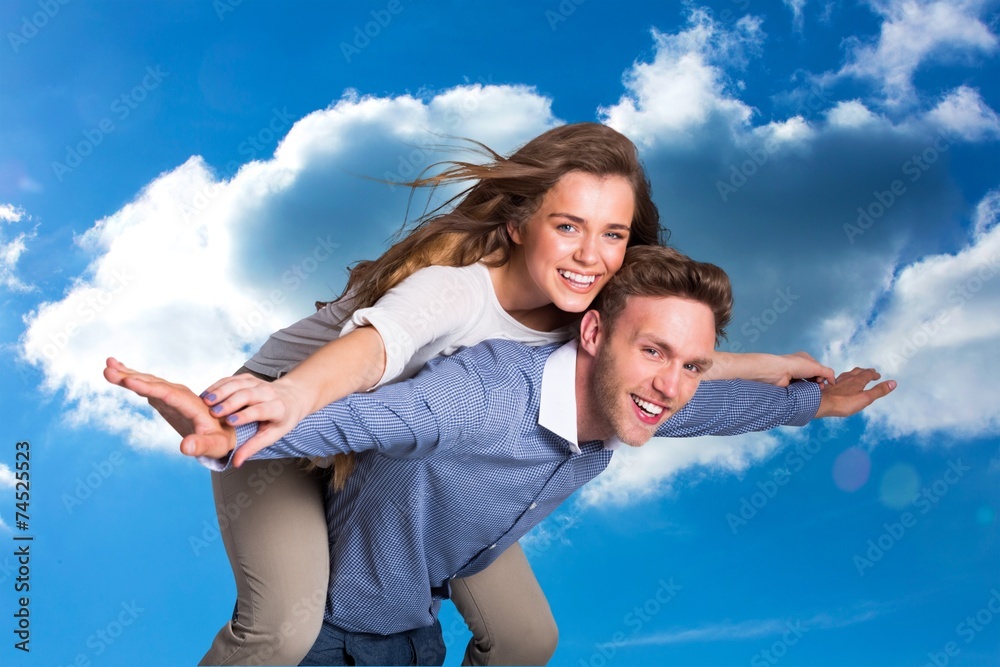 Composite image of smiling young man carrying woman Composite image of smiling young man carrying woman