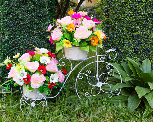 Bike artificial imitations adorned beautiful flowers grass. photo