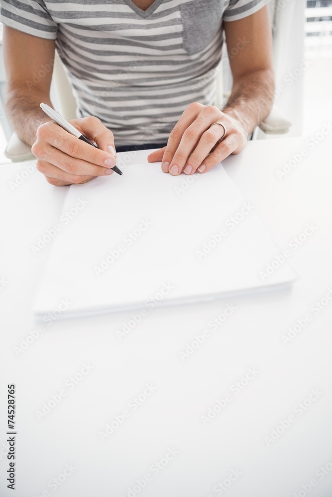Fototapeta premium Casual businessman writing at his desk