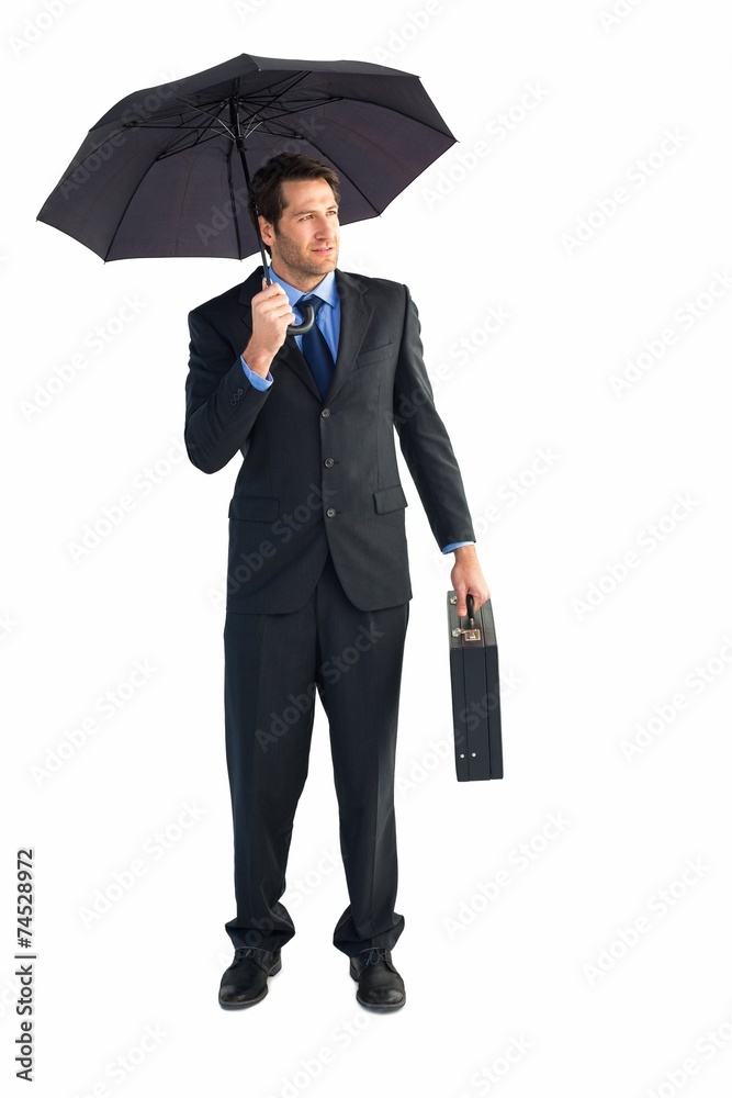 Businessman under umbrella while holding a briefcase Businessman under umbrella while holding a briefcase