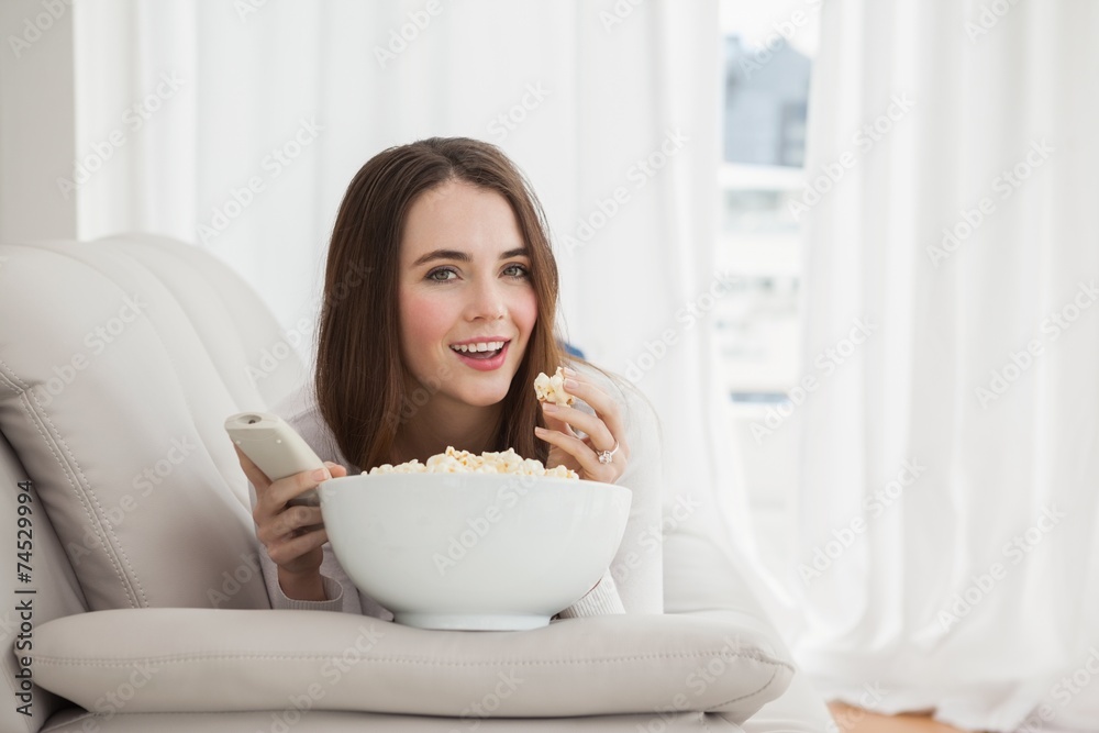 Pretty brunette watching tv with popcorn Pretty brunette watching tv with popcorn