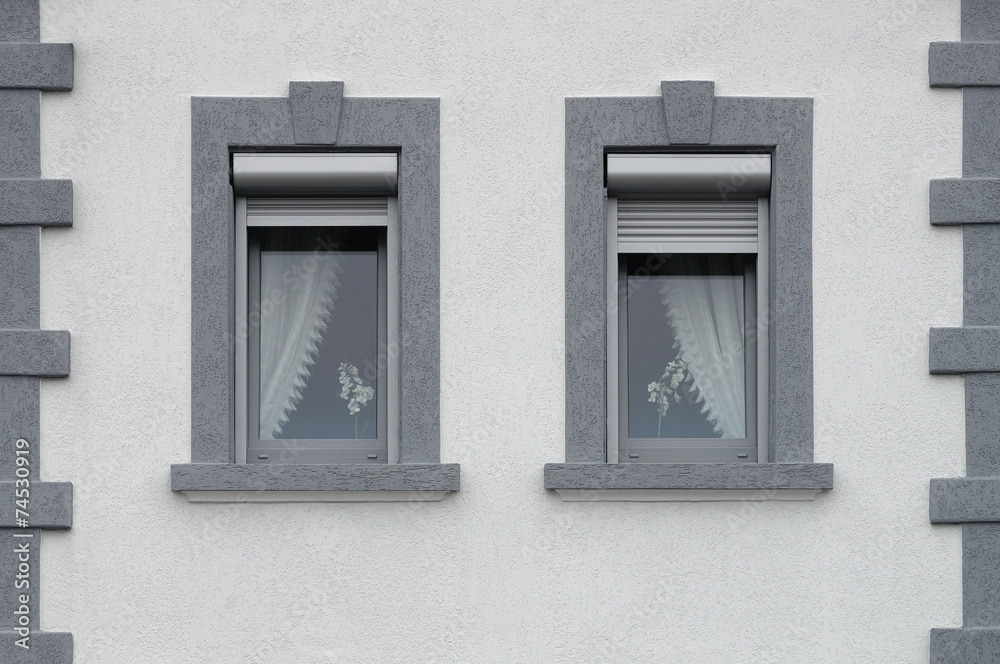 Zwei graue PVC Fenster mit außen liegenden Rollladenkästen Zwei graue PVC Fenster mit außen liegenden Rollladenkästen