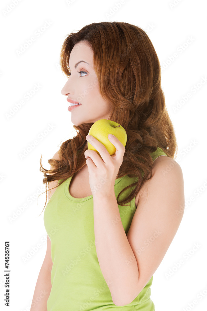 Woman holding an apple and looking somewhere Woman holding an apple and looking somewhere