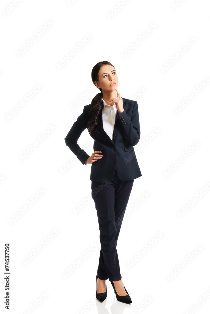 Full length thoughtful businesswoman with a finger under chin Full length thoughtful businesswoman with a finger under chin