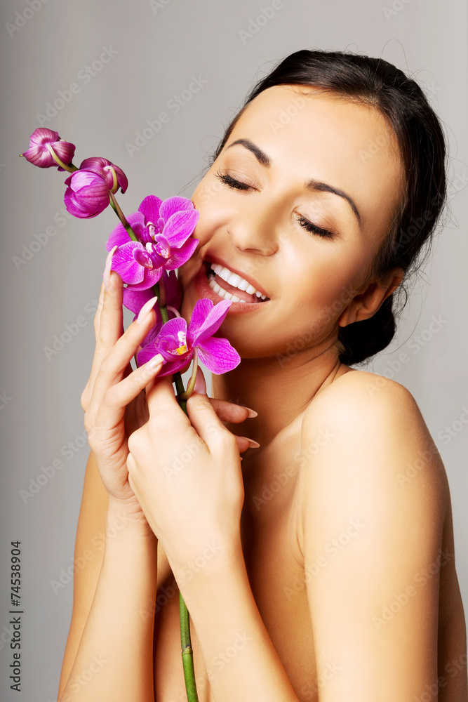 Naked woman with purple orchid and closed eyes Naked woman with purple orchid and closed eyes