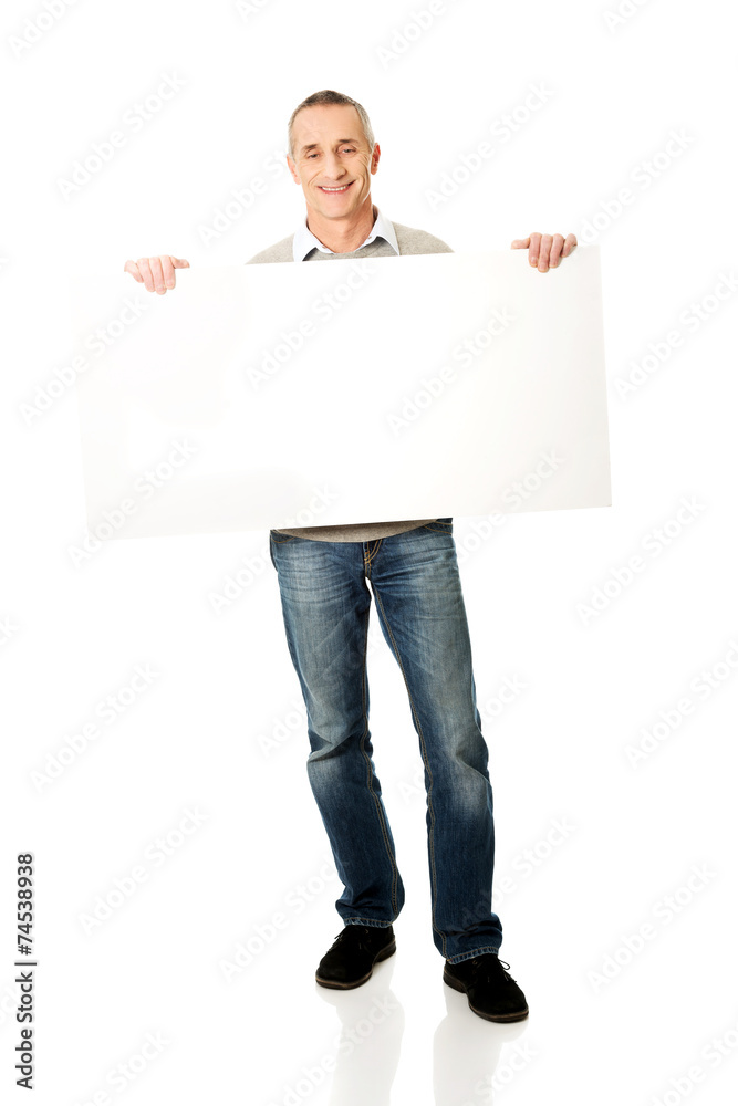 Full length mature man holding empty banner Full length mature man holding empty banner