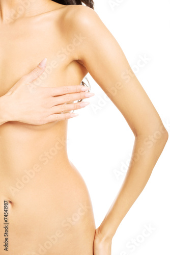 Front view of nude woman examining her breast