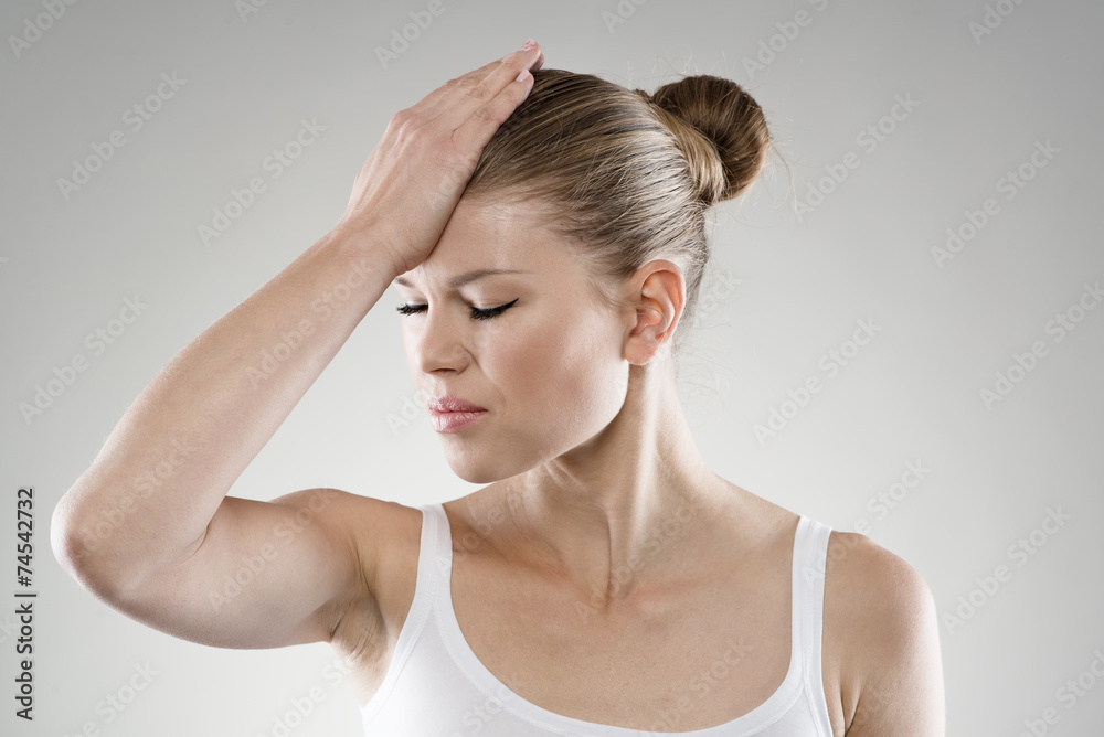 Memory loss. Close-up of woman touching her forehead in pain.