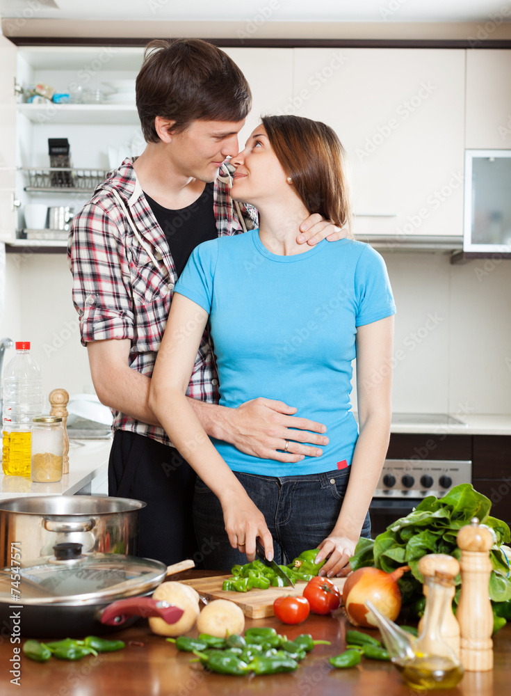 Young loving couple kissing in  kitchen