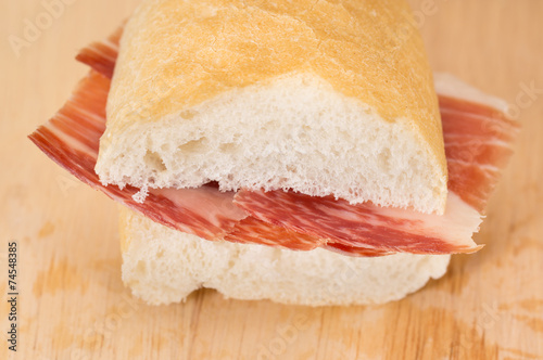 Front view of Serrano ham sandwich over wood