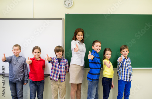 group of school kids and teacher showing thumbs up