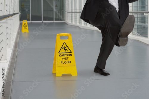 Man in suit slipping on wet floor