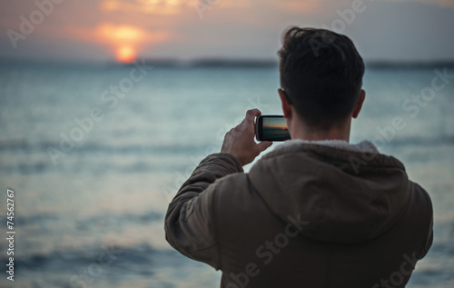 Man takes photographs sunset over the sea