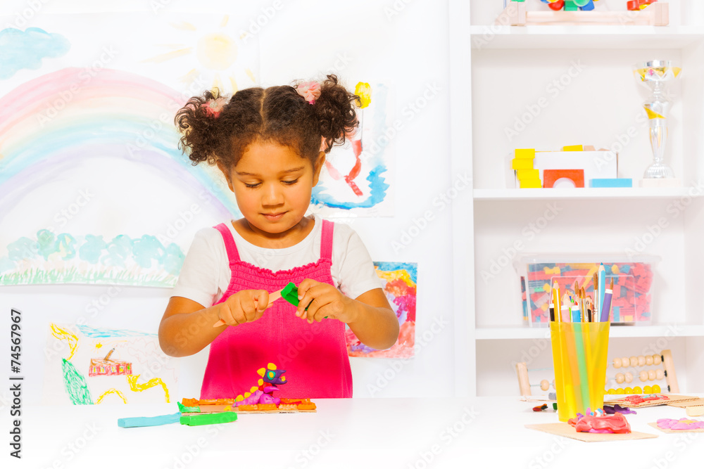 Fototapeta premium Preschool girl play with modeling clay in class