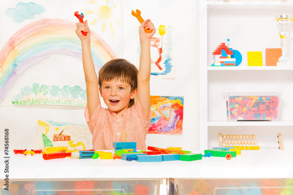 Fototapeta premium Cute happy boy with wrenches in the kindergaten