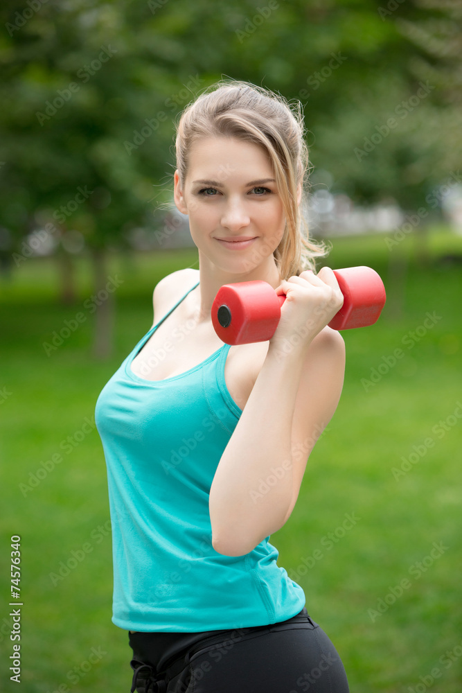 Sports girl exercise with dumbbells in the park Sports girl exercise with dumbbells in the park